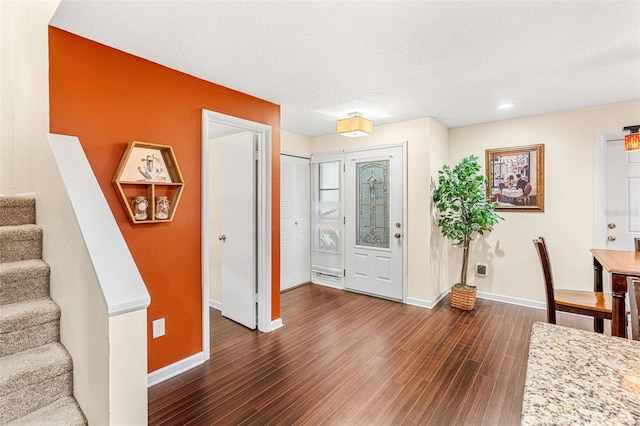 entryway featuring stairs, baseboards, and dark wood-type flooring