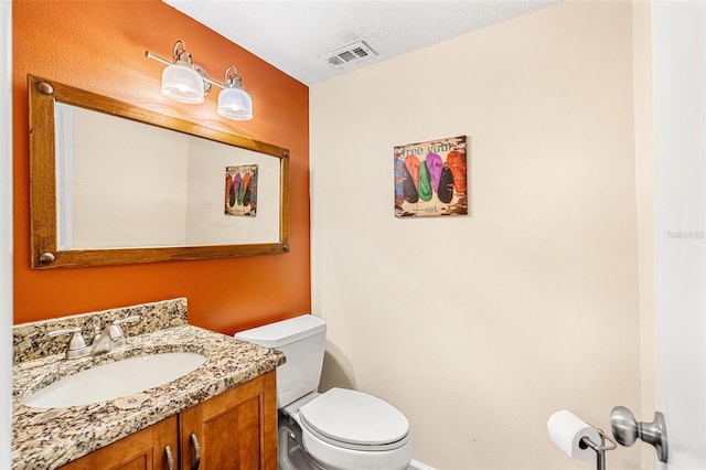 bathroom featuring visible vents, vanity, and toilet