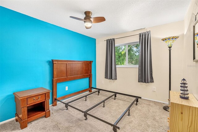 bedroom featuring a textured ceiling, carpet floors, a ceiling fan, and baseboards