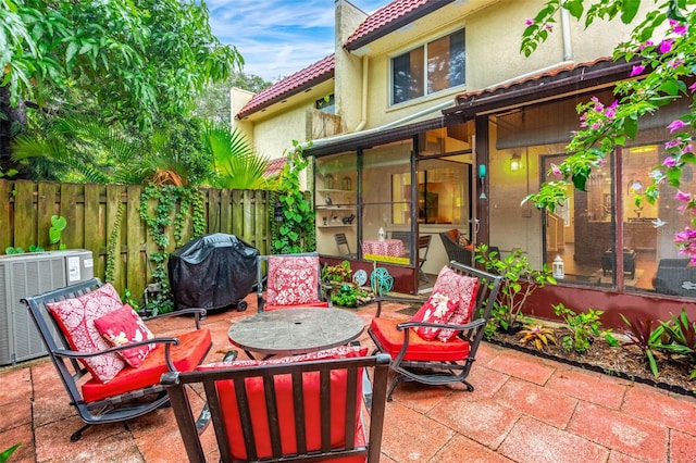 view of patio / terrace with central air condition unit, a sunroom, fence, and area for grilling