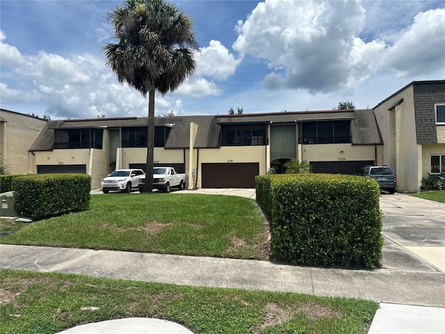 view of front of property with a garage and a front lawn