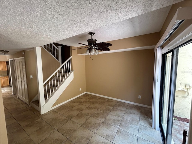 tiled spare room featuring ceiling fan and a textured ceiling