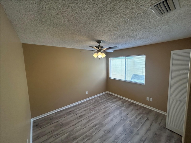 unfurnished bedroom featuring a textured ceiling, wood-type flooring, and ceiling fan