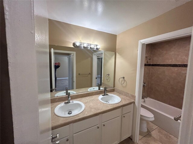 full bathroom featuring tile floors, toilet, tiled shower / bath, and oversized vanity