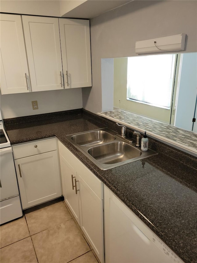 kitchen featuring white cabinets, light tile patterned floors, a wall unit AC, and sink