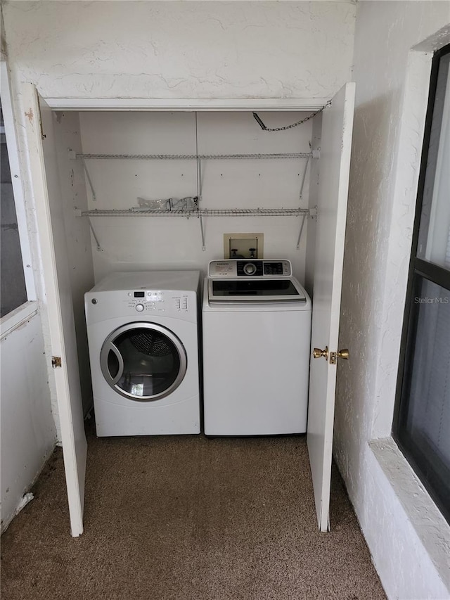 clothes washing area featuring dark colored carpet and separate washer and dryer