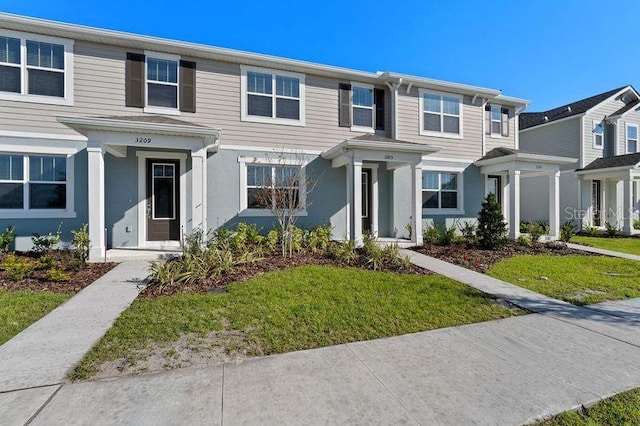 view of property with stucco siding and a front yard