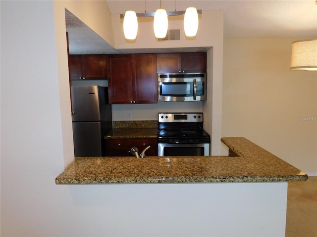 kitchen featuring stone counters, decorative light fixtures, sink, kitchen peninsula, and stainless steel appliances