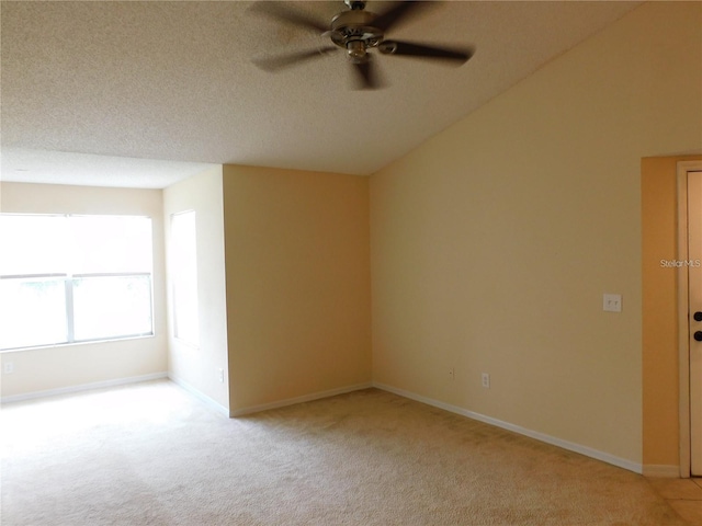 spare room featuring light carpet, ceiling fan, and a textured ceiling