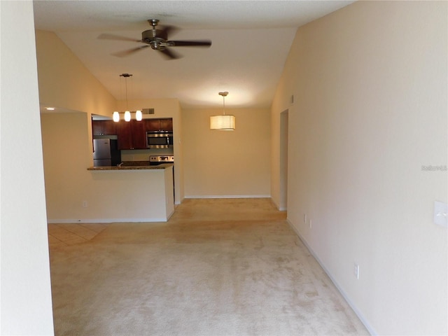 unfurnished living room with vaulted ceiling, light colored carpet, and ceiling fan