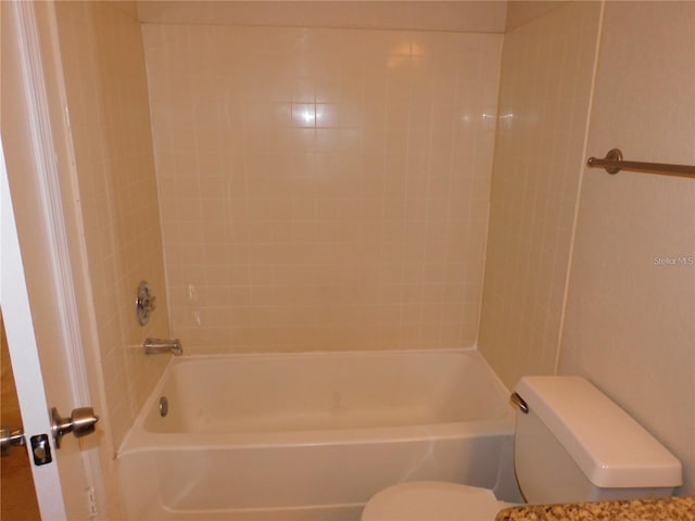 bathroom with tiled shower / bath combo and toilet