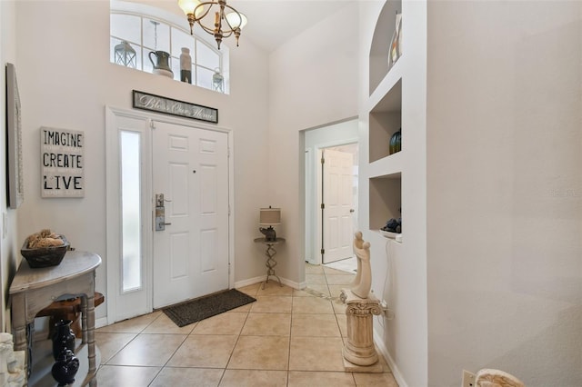 foyer featuring a notable chandelier, light tile patterned flooring, and a high ceiling