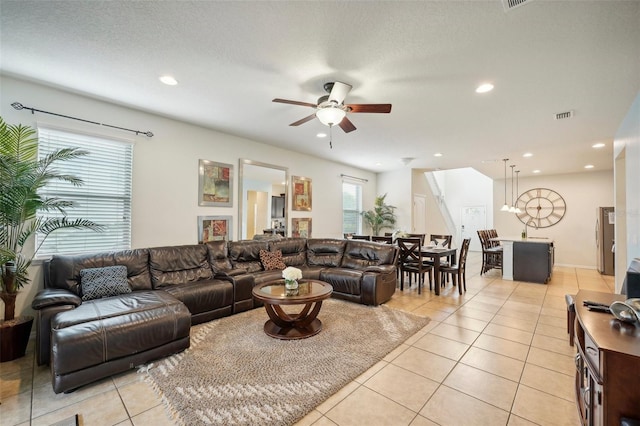 tiled living room featuring ceiling fan and a textured ceiling