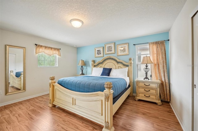 bedroom with wood-type flooring and a textured ceiling