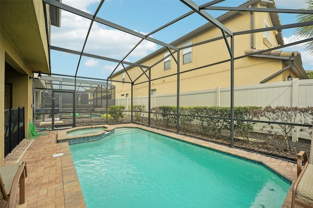 view of swimming pool featuring a patio area, glass enclosure, and an in ground hot tub