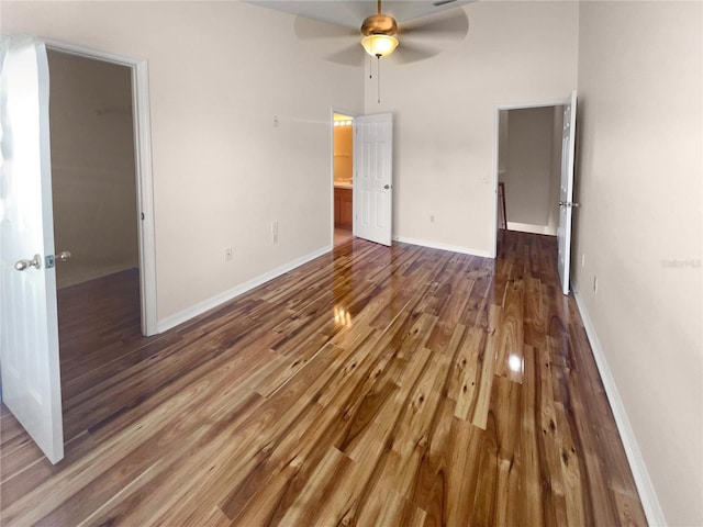 interior space with ceiling fan, wood-type flooring, a walk in closet, and a closet