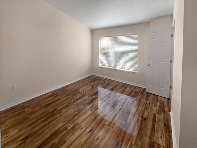 unfurnished room featuring dark wood-type flooring