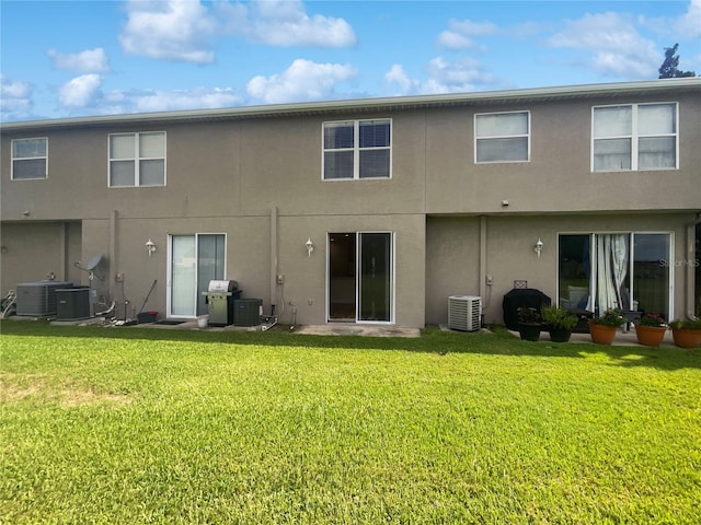 back of property with a lawn and cooling unit