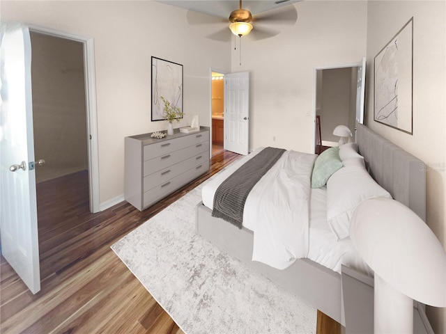 bedroom with hardwood / wood-style floors, ensuite bathroom, and ceiling fan