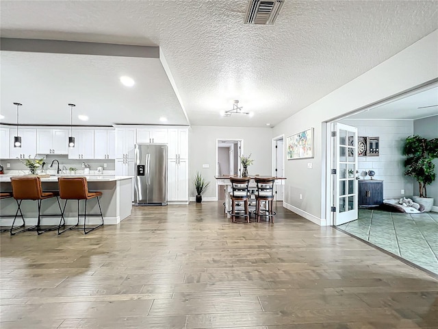 dining space featuring sink, wood-type flooring, and a textured ceiling