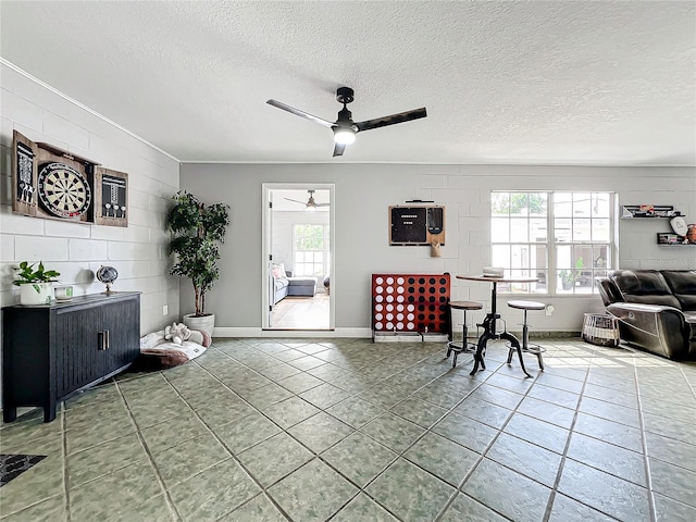 living room featuring tile patterned floors, ceiling fan, and a textured ceiling