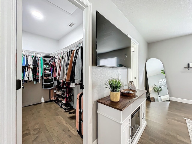 walk in closet with hardwood / wood-style flooring