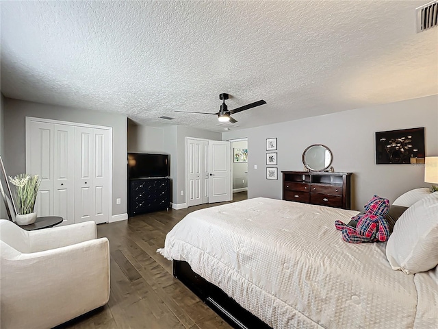 bedroom featuring ceiling fan, dark hardwood / wood-style flooring, and a textured ceiling