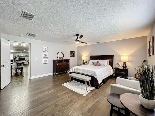 bedroom with a textured ceiling, ceiling fan, and dark wood-type flooring