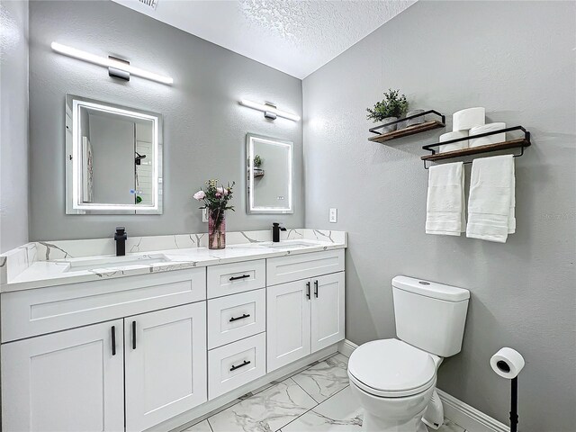 bathroom featuring vanity, a textured ceiling, and toilet