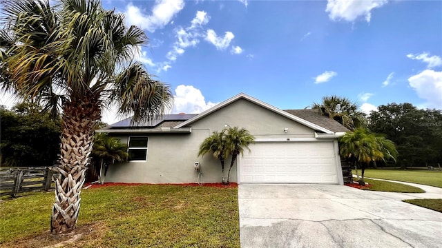 view of front of property featuring a garage, solar panels, and a front lawn