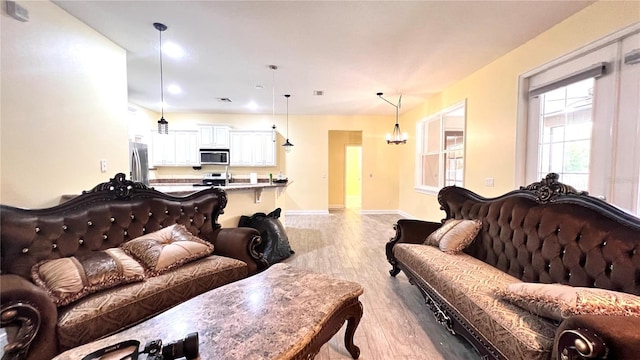 living room featuring light wood-type flooring and a chandelier