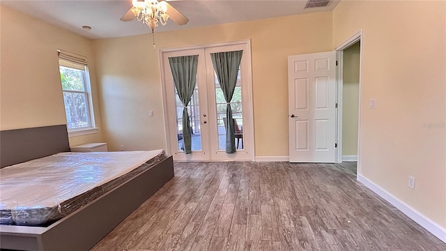 unfurnished bedroom featuring ceiling fan, wood-type flooring, french doors, and access to exterior