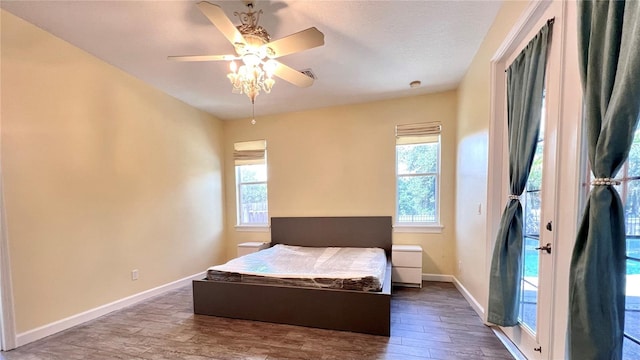 bedroom featuring multiple windows, ceiling fan, and dark hardwood / wood-style floors