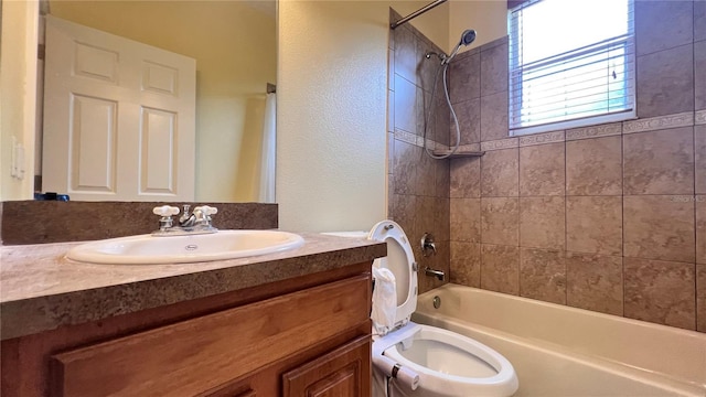 full bathroom featuring toilet, vanity, and tiled shower / bath combo