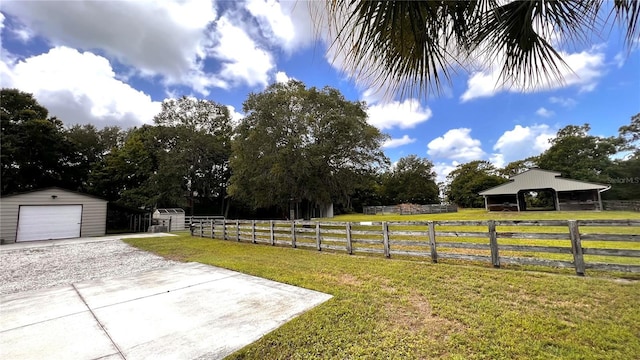 view of yard featuring a rural view, an outdoor structure, and a garage