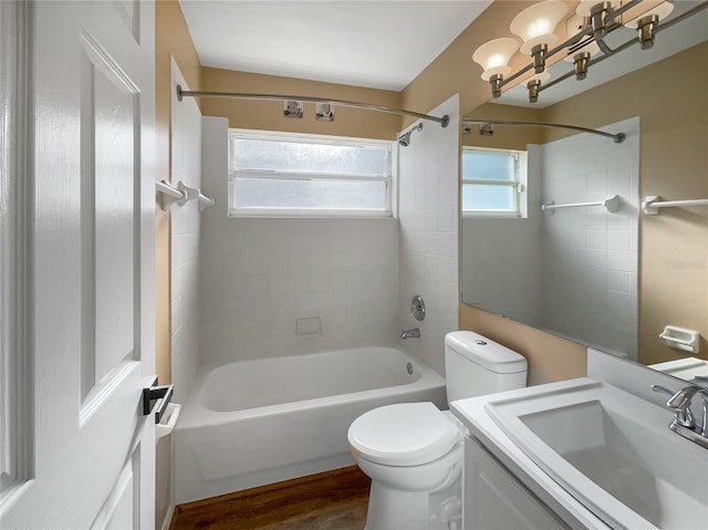 full bathroom with vanity, toilet, hardwood / wood-style floors, and tiled shower / bath