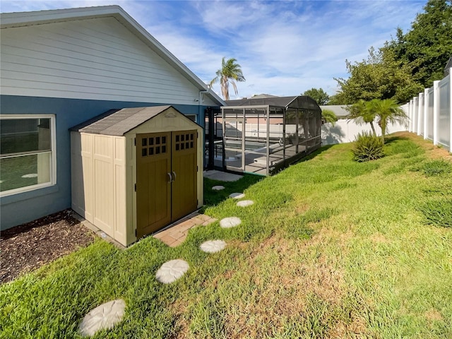 view of yard featuring a storage unit and glass enclosure