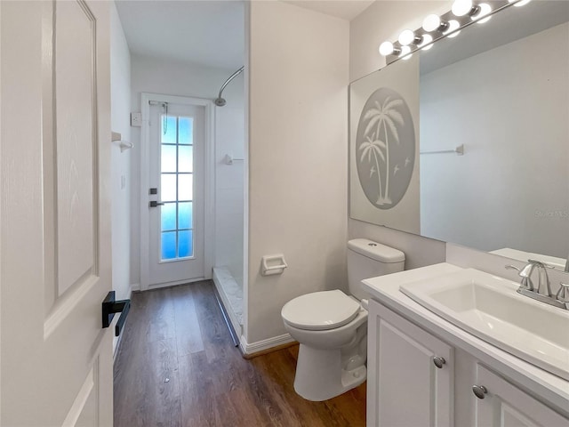 bathroom with wood-type flooring, toilet, walk in shower, and vanity