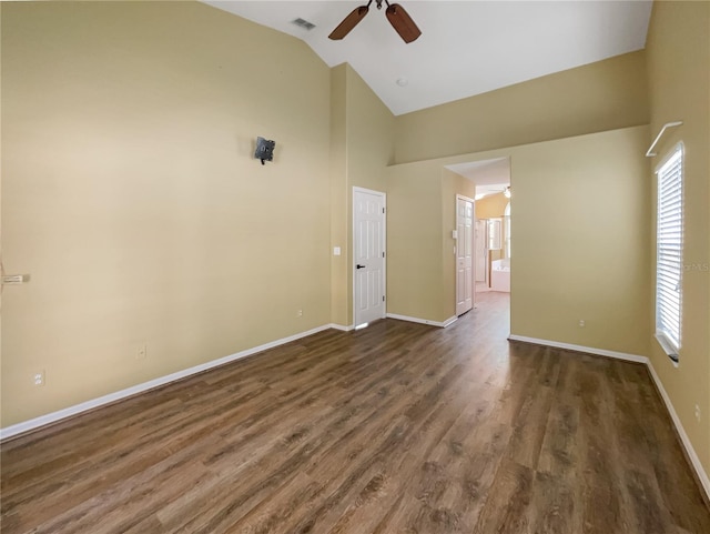 spare room featuring dark wood-type flooring, vaulted ceiling, and ceiling fan