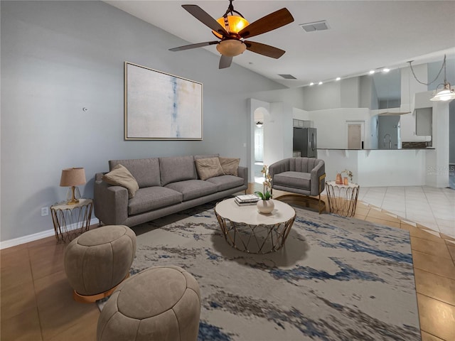 living room featuring vaulted ceiling, ceiling fan, sink, track lighting, and light tile patterned flooring