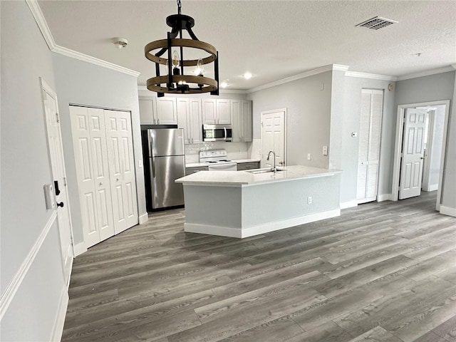 kitchen with stainless steel appliances, sink, white cabinets, and dark hardwood / wood-style flooring