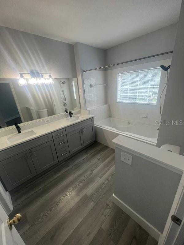 bathroom with wood-type flooring, shower / washtub combination, and vanity