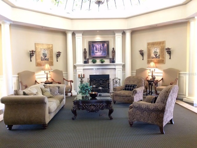 carpeted living room with decorative columns and a high end fireplace