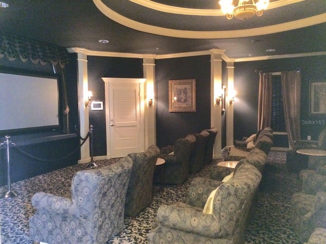 cinema room featuring a raised ceiling and ornamental molding