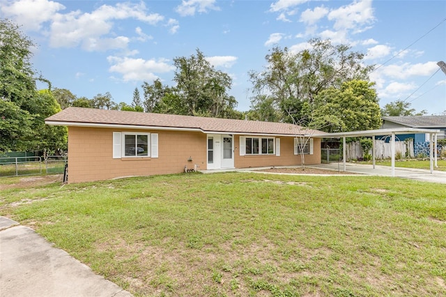 ranch-style home featuring a front lawn and a carport