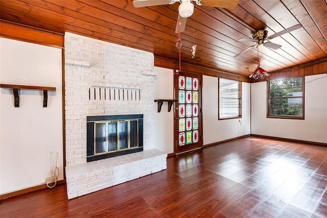 unfurnished living room with ceiling fan, wood-type flooring, wooden ceiling, and a brick fireplace