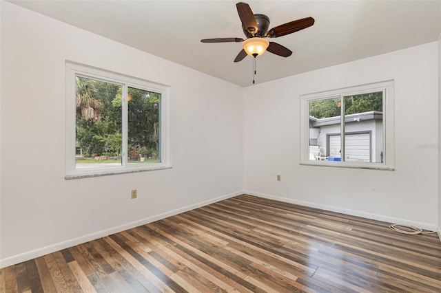 empty room with ceiling fan, plenty of natural light, and dark hardwood / wood-style floors