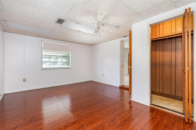 unfurnished bedroom featuring ceiling fan, dark hardwood / wood-style flooring, and a closet