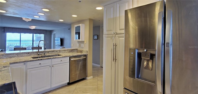 kitchen featuring light stone countertops, sink, white cabinets, and stainless steel appliances