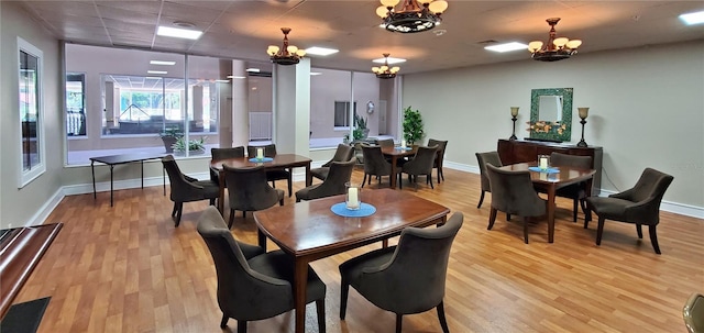 dining space with light wood-type flooring and an inviting chandelier